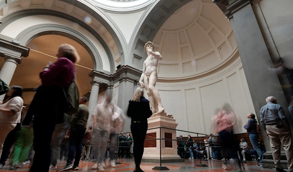 Tourists take photos in front of Michelangelo's "David statue" in the Accademia Gallery in Florence, Italy, March 28, 2023 (AP)