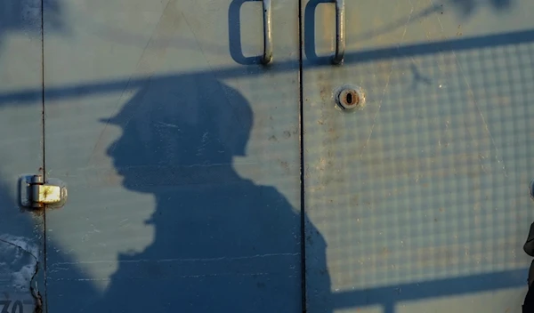 The shadow of an Indian paramilitary soldier is cast on an armored vehicle as he guards at a busy market in Srinagar, Indian controlled Kashmir, August 1, 2023. (AP)