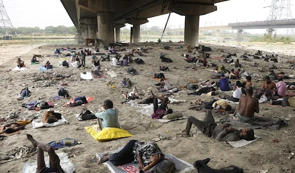 Homeless people sleeping under a bridge on a hot day in New Delhi, on May 20, 2022. Last July, a study calculated how much climate-related loss richer countries have caused poorer countries through their carbon emissions. (AP)