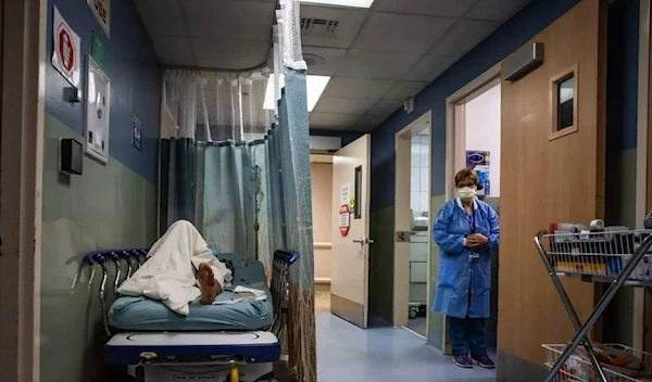 A patient rests in a corridor waiting for a room at Providence Cedars-Sinai Tarzana Medical Center in Tarzana, California on January 3, 2021. (AFP VIA Getty Images)