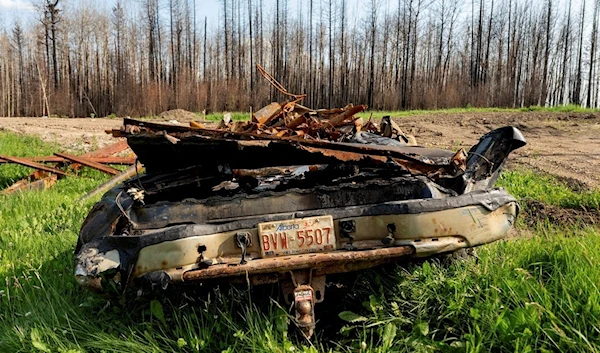 A scorched car rests in the yard of a home destroyed by a wildfire in the East Prairie Metis Settlement, Alberta, on Tuesday, July 4, 2023. (AP)