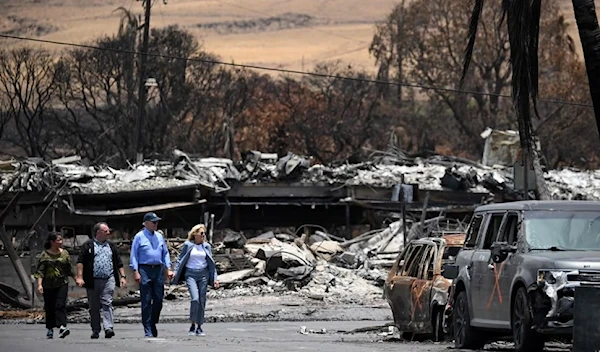 US President Joe Biden (second right), US first lady Jill Biden (right), Hawaii Governor Josh Green (second left) and Jaime Green, first lady of Hawaii, visit an area devastated by wildfires in Lahaina on Monday (AFP)