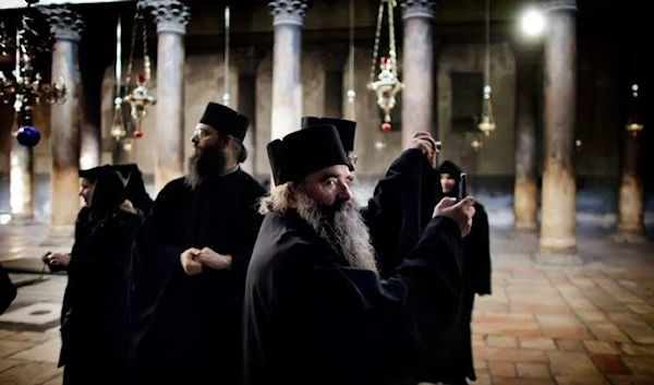 Orthodox monks tour the Church of the Nativity in Bethlehem, situated in the occupied West Bank near Al-Quds. (AFP via Getty Images)