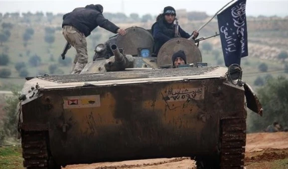 The file photo shows the al-Nusra Front terrorists riding a captured tank near Idlib, northwestern Syria. (AFP)