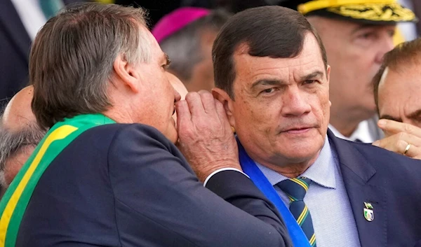 Brazils President Jair Bolsonaro whispers in the ear of Defense Minister Paulo Sergio Nogueira during a military parade to celebrate the bicentennial of the country's independence from Portugal in Brasília, Brazil, Wednesday, Sept. 7, 2022. (AP)