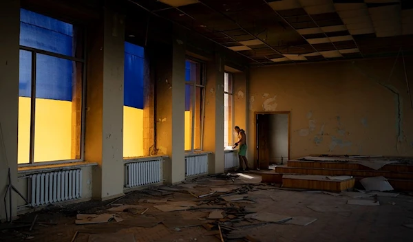 A construction worker looks out of a window of the damaged city council building in Izyum, Ukraine, Tuesday, Aug. 22, 2023. (AP)