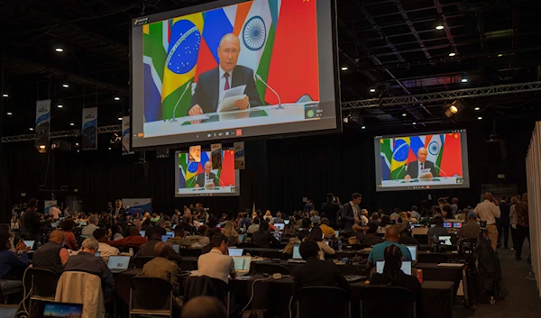 Members of the media watch Russia's President Vladimir Putin address via videolink the 2023 BRICS Summit in Johannesburg, South Africa, Wednesday, Aug. 23, 2023. (AP)