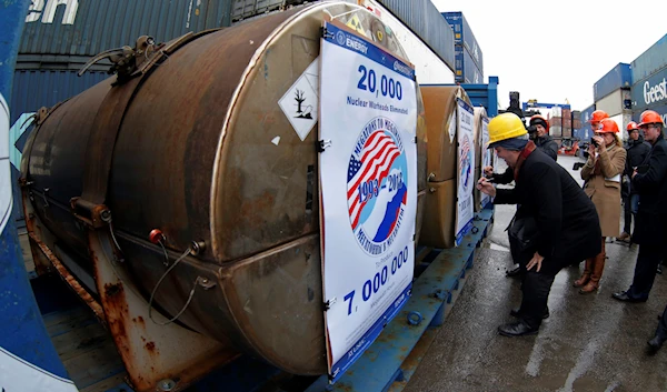 Representatives of participating companies sign containers with uranium to be used as fuel for nuclear reactors, prior to loading them aboard Atlantic Navigator ship, on a port in St. Petersburg, Russia, Thursday, Nov. 14, 2013. (AP)