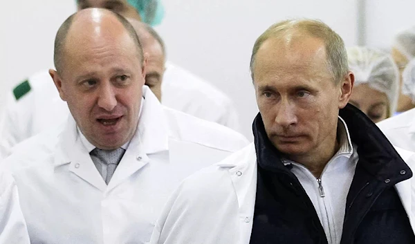 In this Sept. 20, 2010 photo, late Wagner PMC chief and businessman Yevgeny Prigozhin shows Vladimir Putin around his facility that produces school meals outside St. Petersburg, Russia (AP)