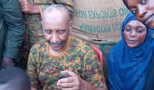 Sudanese army chief Abdel Fattah Al-Burhan meets a number of residents of Al-Hara 100, in Omdurman, and drinks coffee with them on August 24, 2023. (Social media)