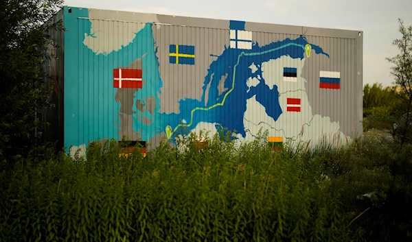 A painting showing the Nord Stream pipelines is displayed on a container near the Nord Stream 1 Baltic Sea pipeline in Lubmin, Germany, July 20, 2022 (AP)