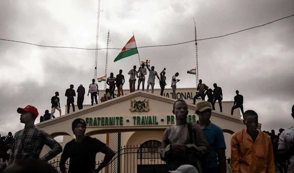 Demonstrators hold up a Nigerien flag in Niamey, Niger on August 3, 2023 (AFP)