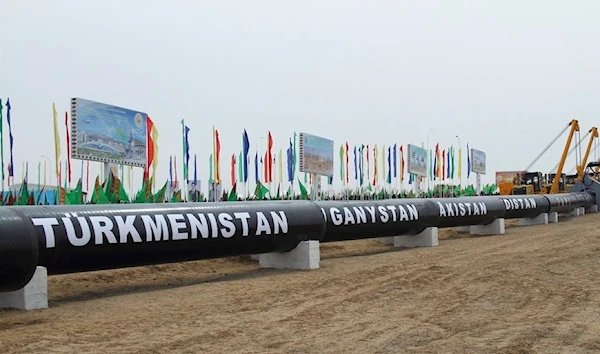 In this Feb. 23, 2018 photo, workers at the Turkmen-Afghan border prepare to weld the first link crossing the frontier during the integration ceremony of the pipeline in Serhetabat, Turkmenistan (AP Photo/Alexander Vershinin)