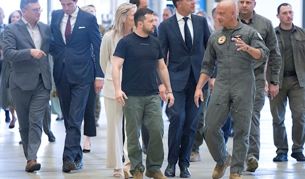 Ukrainian President Volodymyr Zelensky and Dutch caretaker Prime Minister Mark Rutte, listen to an F-16 fighter jet pilot in Eindhoven, Netherlands, August 20, 2023 (AP)