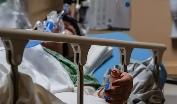 A Covid-19 patient uses a continuous positive airway pressure (CPAP) machine to help her breathe in a Covid holding pod at Providence St. Mary Medical Center in Apple Valley, California on January 11, 2021. (AFP via Getty Images)