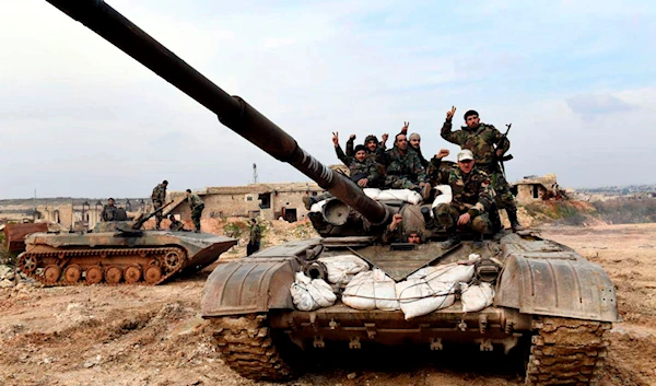 This Monday, Jan. 27, 2020, photo, released by the Syrian official news agency SANA, Syrian army soldiers flash the victory sign as they stand on their tank in western rural Aleppo, Syria (SANA via AP)