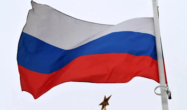 A Russian flag flies in front of a ruby star atop one of the Kremlin's towers in downtown Moscow. (AFP)