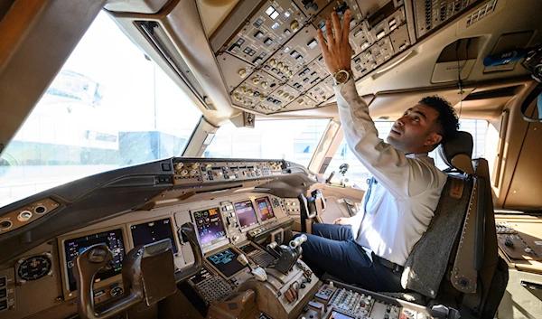 Pilot Omar Morsi checks controls in the cockpit of a United Airlines Boeing 777 aircraft at Newark Liberty International Airport in Newark, New Jersey, on March 9, 2023 (AFP)