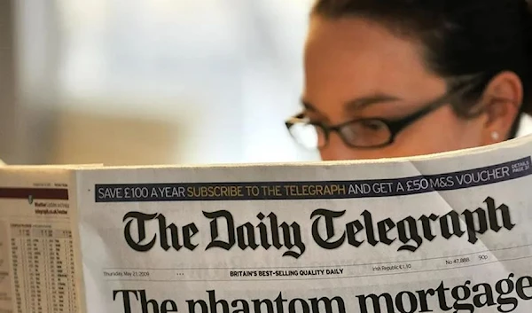 A woman reads a copy of the Daily Telegraph newspaper in London, on May 21, 2009. (AFP)