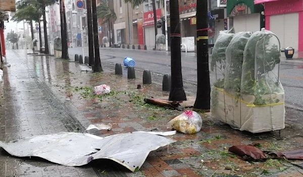 Scattered debris litters a downtown street as high winds brought by Typhoon Khanun hit the city of Naha, Okinawa prefecture. (AFP) /