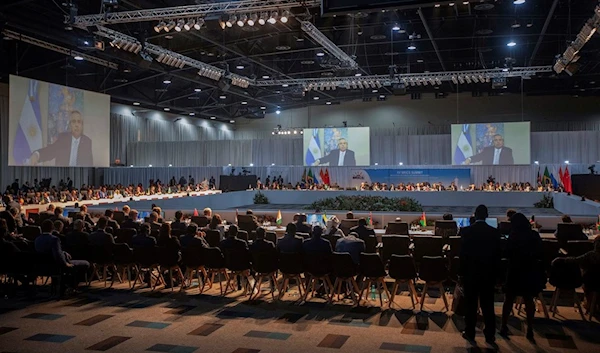 Argentine President Alberto Angel Fernandez appears on a screen as he addresses the 15th BRICS Summit, in Johannesburg, South Africa, Thursday, Aug. 24, 2023 (Kim Ludbrook/Pool via AP)