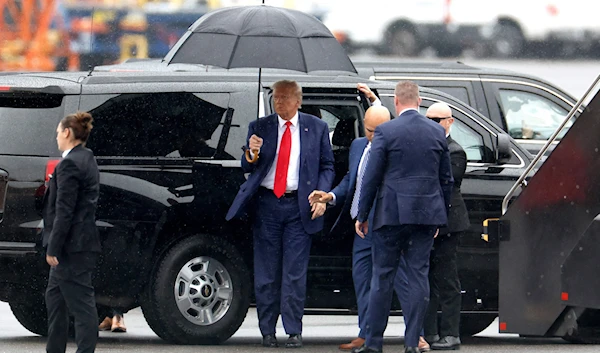 Former U.S. President Donald Trump holds an umbrella as he arrives at Reagan National Airport following an arraignment in a Washington, D.C. court in Arlington, Virginia, U.S., Aug. 3, 2023. (AFP)