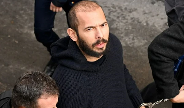 Andrew Tate arrives handcuffed and escorted by police at a courthouse in Bucharest, Romania on February 1, 2023. (AFP/Getty Images)