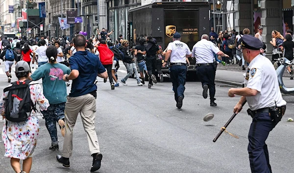 Plates and chairs are thrown near Chelsea during a 'giveaway' event in New York on August 4, 2023 (Photo: AFP)