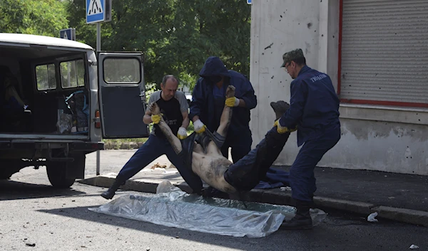 Funeral workers load a body of a man killed during shelling conducted by Ukrainian forces, in the Donetsk People's Republic, July 31, 2023 (AP)