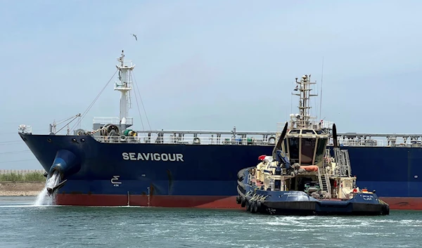 A tugboat pushes the Seavigour after it suffered a mechanical malfunction at the 12 kilometers (7.5 miles) mark of the canal, Egypt, June 4, 2023 (AP)