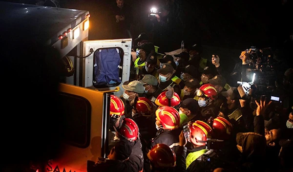 Rescue workers carry the body of 5-year-old Rayan and place it in an ambulance after it was retrieved from a hole in which he was stuck for several days, in the village of Ighran in Morocco's Chefchaouen province, Saturday, Feb. 5, 2022. (AP)