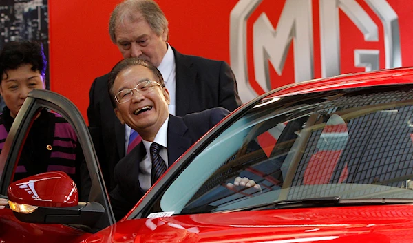 Chinese Premier Wen Jiabao smiles as he gets into a MG6 car during his visit to the MG motor plant in Birmingham, central England, Sunday, June 26, 2011. (AP)