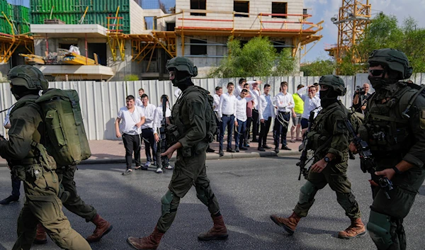 Israeli security forces are seen deployed at the site of a shooting attack in the West Bank Israeli settlement of Maale Adumim, Aug 1, 2023 (AP)