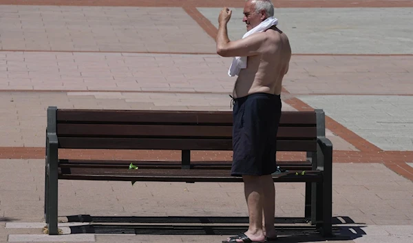 A man puts on his shirt in Madrid, Spain, on June 24, 2023, where temperatures rose to 35C with the weather that was expected to become hotter in the coming months. (AP)