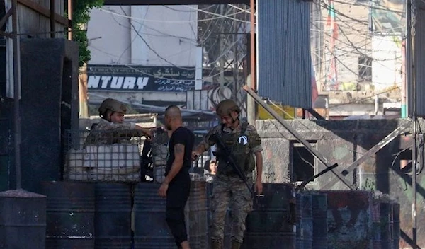 A man speaks with Lebanese soldiers as they stand guard at one of the entrances to the Ain al-Hilweh camp for Palestinian refugees, in Lebanon’s southern coastal city of Saida on September 8, 2023 (AFP)