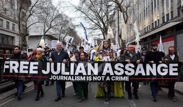 Supporters of WikiLeaks founder Julian Assange take part in a Night Carnival for Assange march in London, February on 2023. (AFP)