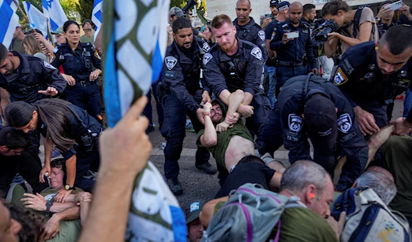 Israeli police disperse demonstrators, mostly military reservists, who block a road outside the house of Israeli Justice Minister Yariv Levin during a protest Monday, Sept. 11, 2023 (AP)