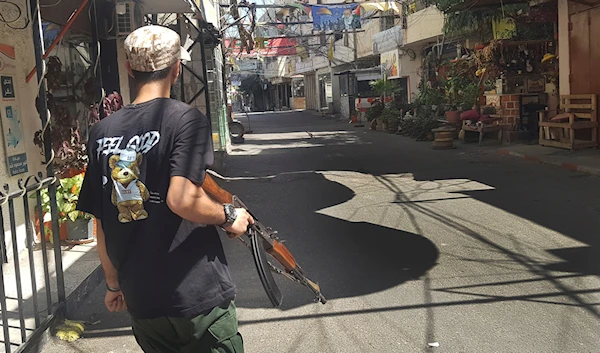 A fighter of the Palestinian Fatah group crosses a street during clashes with Islamist militants in the Palestinian refugee camp of Ain el-Hilweh, Saida, Friday, Sept. 8, 2023 (AP)