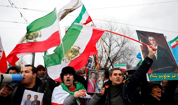 An activist holds a picture of Shah Mohammad Reza Pahlavi during a gathering in support to Iran's anti-government protesters, in Strasbourg, eastern France, Monday, Jan. 16, 2023. (AP)