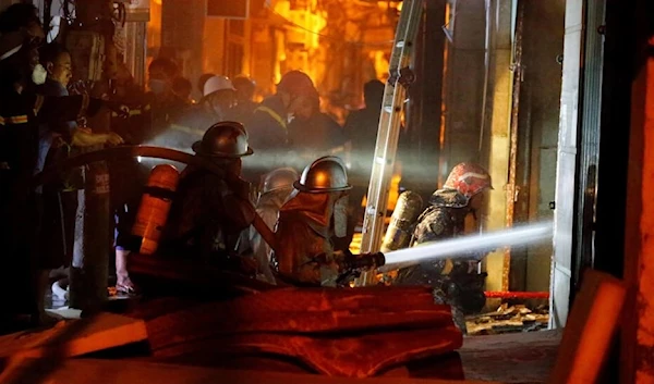 Firefighters work to put out a fire and rescue people at an apartment block in Hanoi September 13, 2023 (AFP)