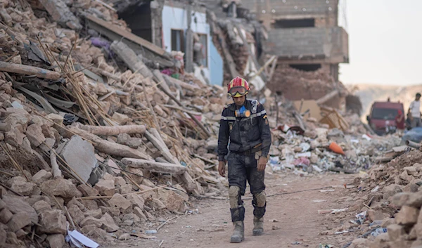 A rescue worker walks through rubble which was caused by the earthquake, in the town of Imi N'tala, outside Marrakech, Morocco, Sept. 13, 2023 (AP)