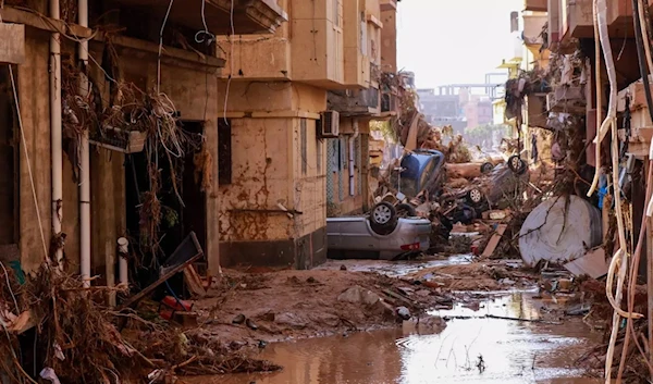 Overturned cars lay among other debris caused by flash floods in Derna, eastern Libya, on 11 September 2023. (AFP)