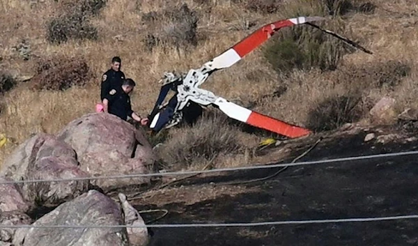 Investigators walk around rotor blades from one of the crashed helicopters on a burned hillside in Cabazon, California, on August 7, 2023. (AFP via Getty Images)