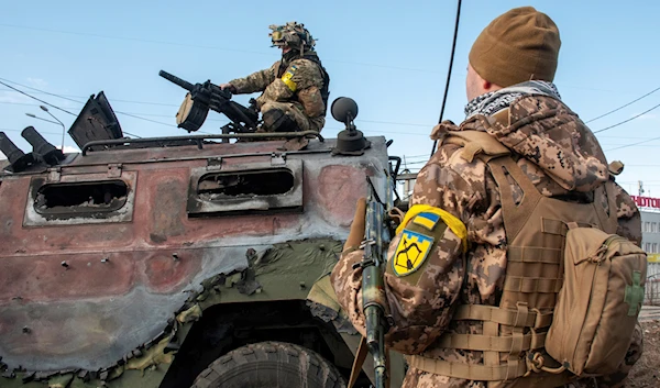 Ukrainian soldiers inspect a damaged military vehicle after fighting in Kharkiv, Ukraine, Sunday, Feb. 27, 2022 (AP)