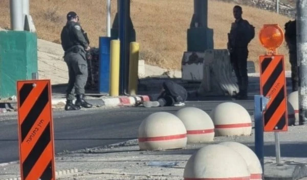 A young Palestinian man lying on the ground after being shot by occupation soldiers at the Mazmuria checkpoint near Occupied Al-Quds. (Israeli media)