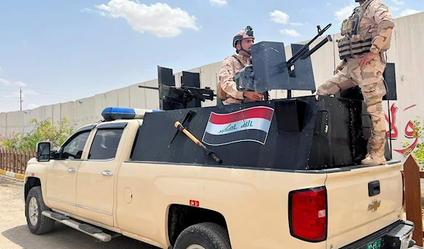 Iraqi soldiers stand on a truck ion a base in Sinjar, Iraq, May 3, 2022 (AP)