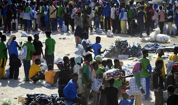 Migrants stand in the Lampedusa's migrant reception center, Sicily, Sept. 14, 2023. (AP)