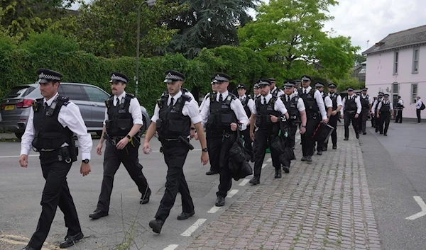 Police officers leave as a car crashed into a primary school building in Wimbledon, London, Thursday, July 6, 2023 (AP)