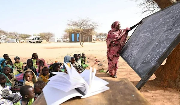 Sudanese refugee Assaniah Ahmad Hussein teaches an outdoor class at Kouchaguine-Moura refugee camp in eastern Chad.