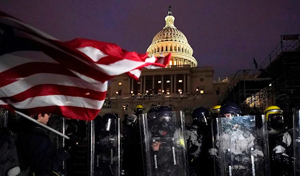 Police stand behind their shields outside the Capitol after a day of rioting back in January 2021 (AP)